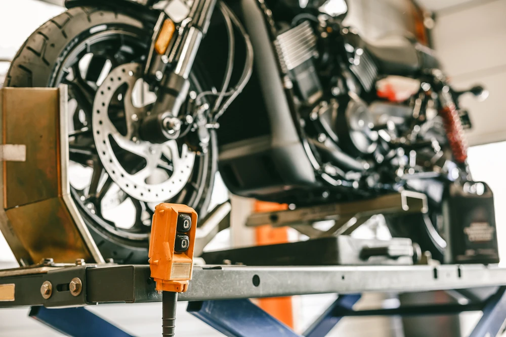 Extérieur automobile, professionnel en chemise bleue complétant un formulaire sur presse-papiers près d'un véhicule avec capot ouvert